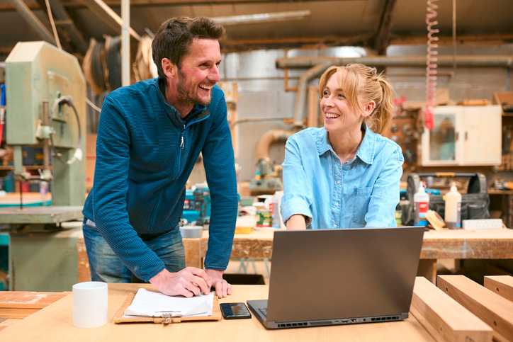 A husband and wife team in a carpentry workshop.
